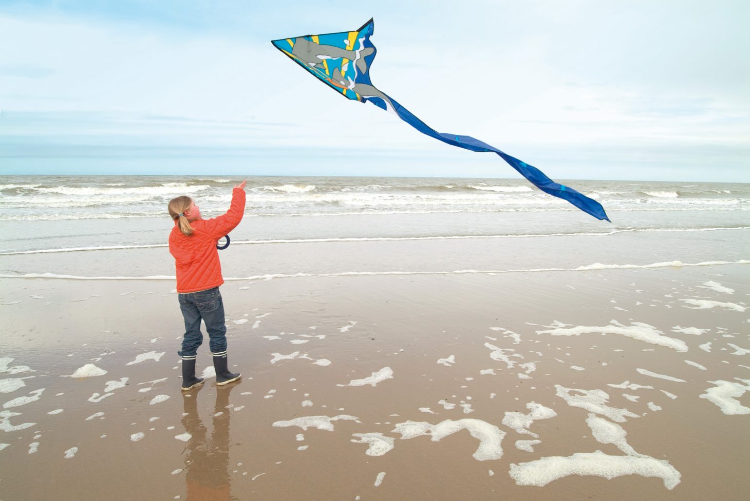 young girl flying a kite on the beach